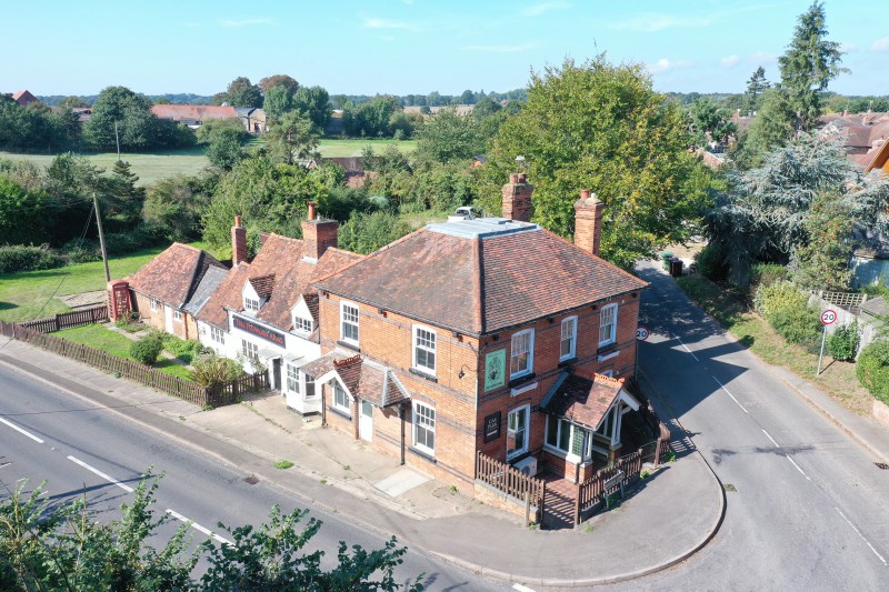Traditional red brick country pub on village corner, with pitched tiled roofs and rural countryside views